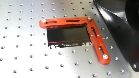 Fiber laser etching a high-contrast QR code on a black anodized aluminum smart business card.