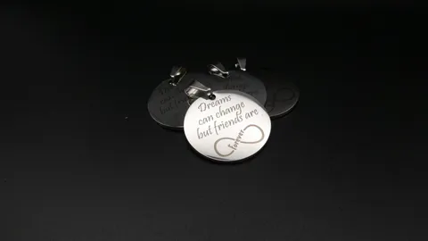 Custom engraved stainless steel friendship medallions featuring a crisp infinity symbol and typography.