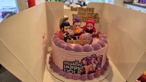 Custom birthday cake decorated with character figures, purple icing, and a laser-cut wooden La Multi Ani Laura topper.